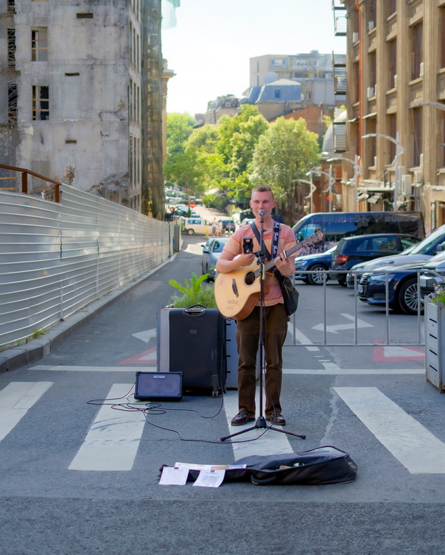30 - Busker playing guitar near the demolition of the former Bancorex headquarters on Calea Victoriei in Bucharest